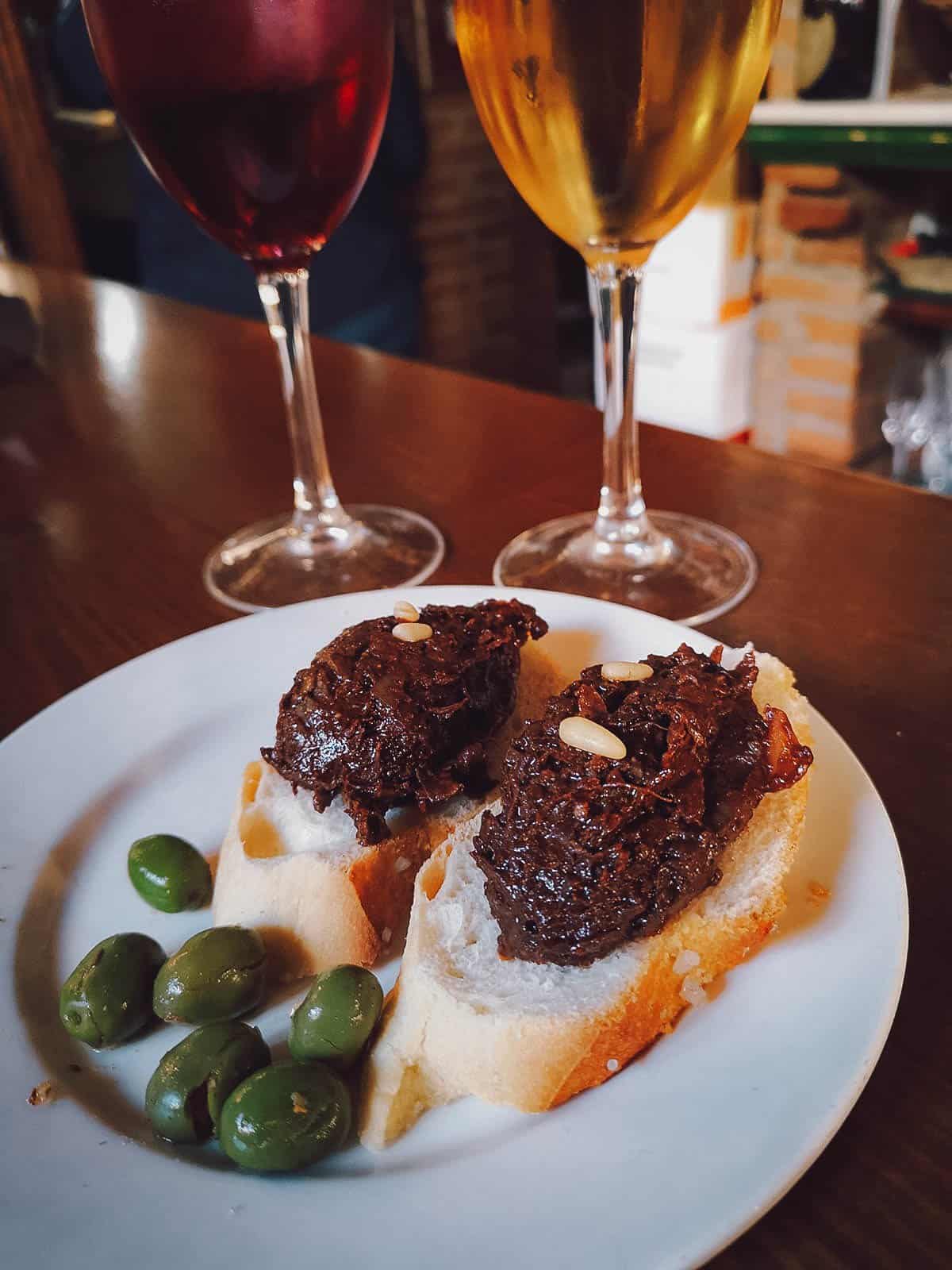 그라나다의 인기있는 스페인 타파스 바에서 흰색과 적포도주를 곁들인 모르실라