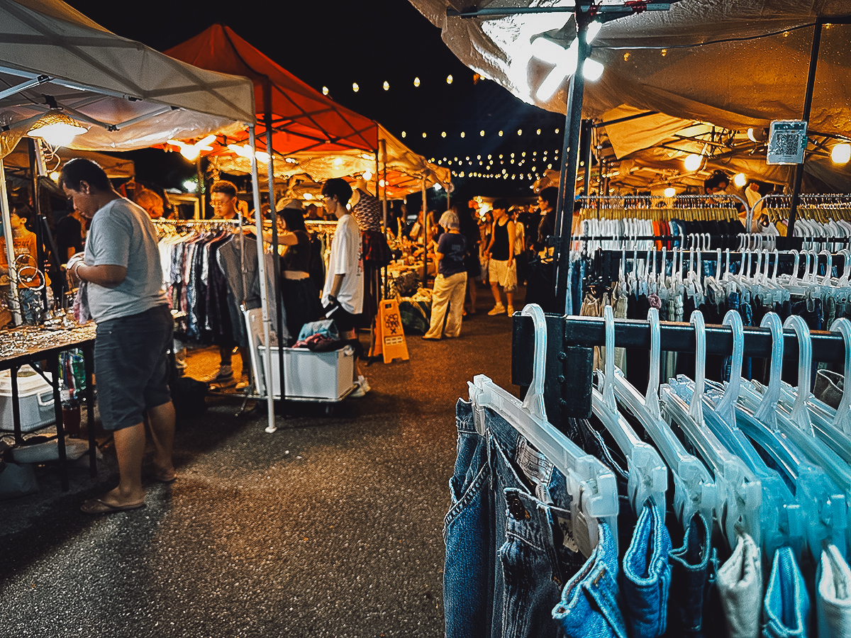 Clothing for sale at Night Ground Flea Market sign in Chiang Mai