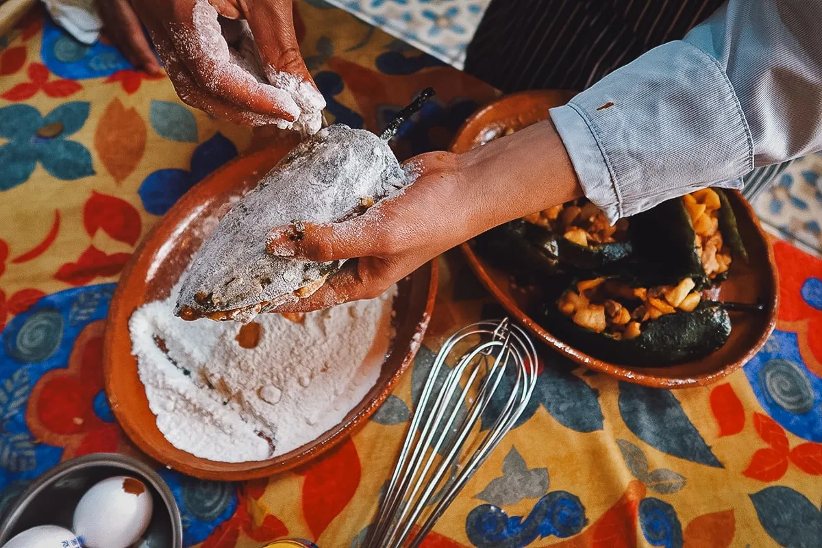 Coating the stuffed poblano peppers in flour