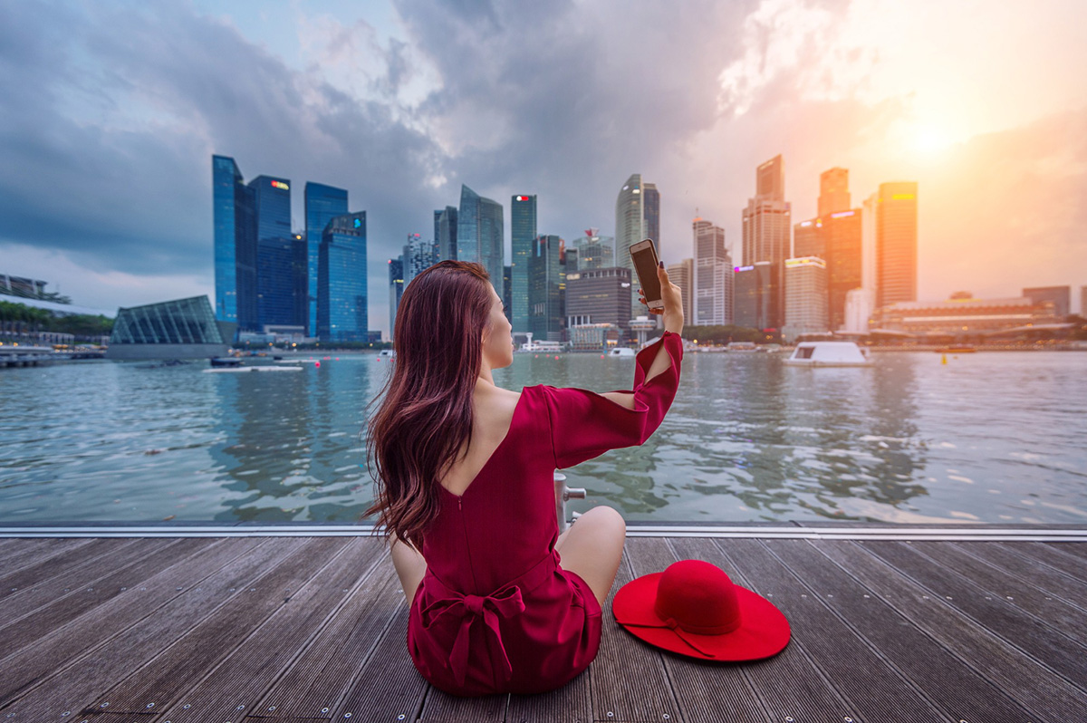 Woman sitting in Singapore taking selfie