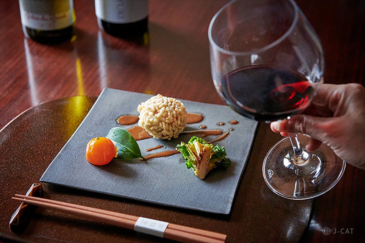 Beautifully plated Japanese dish with a glass of wine